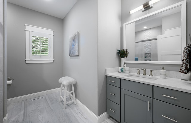 bathroom with wood-type flooring, a shower with shower door, and vanity