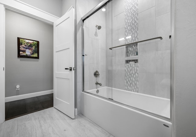 bathroom with bath / shower combo with glass door and hardwood / wood-style floors