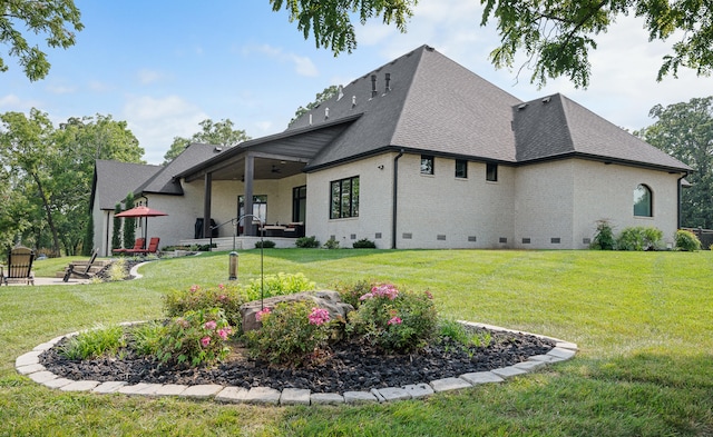 back of house featuring a lawn and a patio area