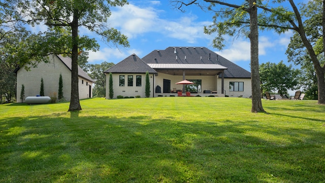 rear view of house with a lawn and a patio