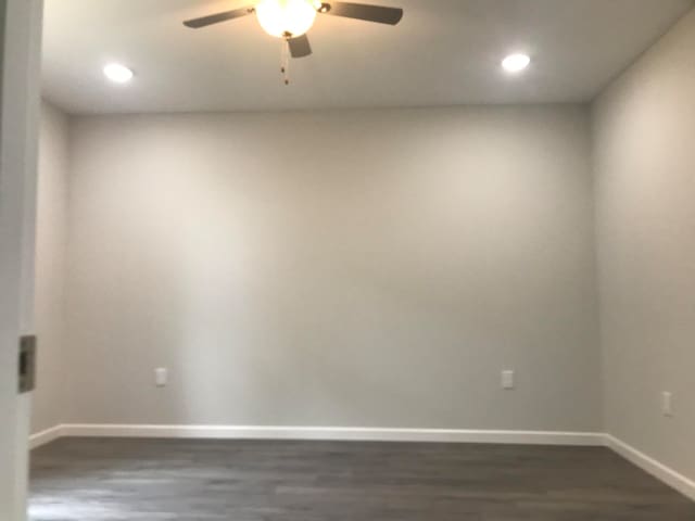 empty room featuring ceiling fan and dark wood-type flooring