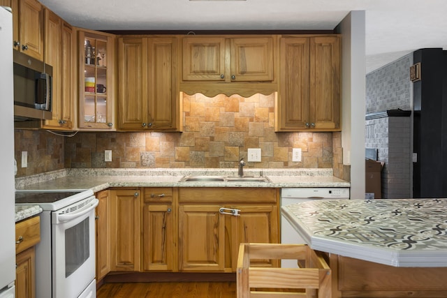 kitchen featuring decorative backsplash, light stone countertops, electric stove, and sink