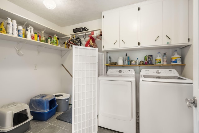 laundry area with a textured ceiling, independent washer and dryer, light tile patterned floors, and cabinets