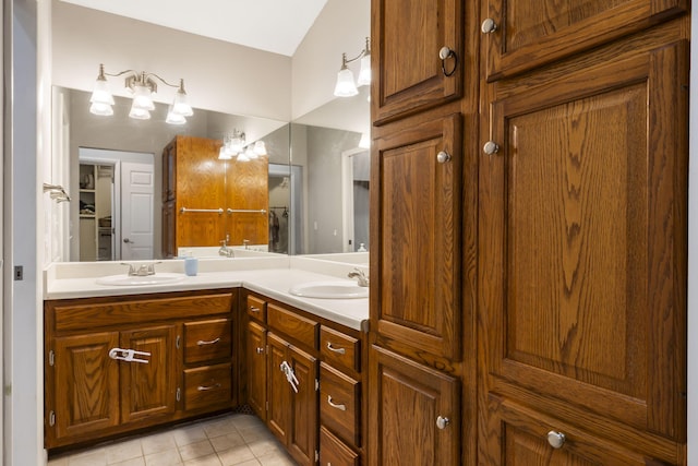 bathroom with tile patterned floors, vaulted ceiling, and vanity