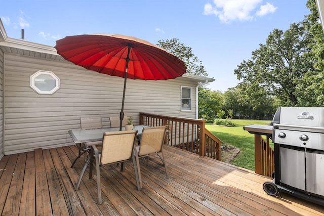 wooden deck featuring area for grilling and a lawn