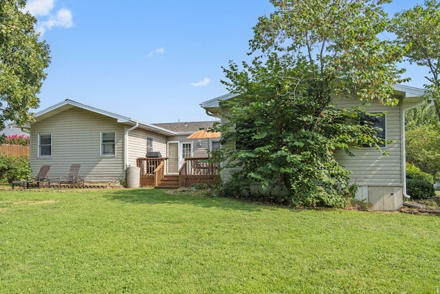 back of property with a lawn and a deck