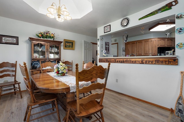 dining space with an inviting chandelier and light hardwood / wood-style flooring