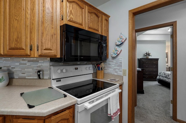 kitchen featuring carpet floors, electric stove, and backsplash