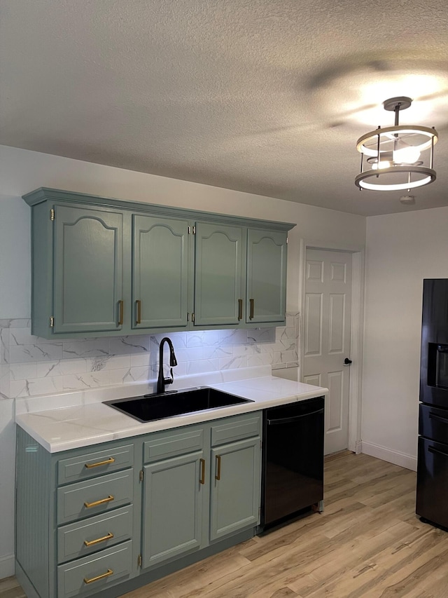 kitchen with black appliances, sink, light hardwood / wood-style floors, and backsplash