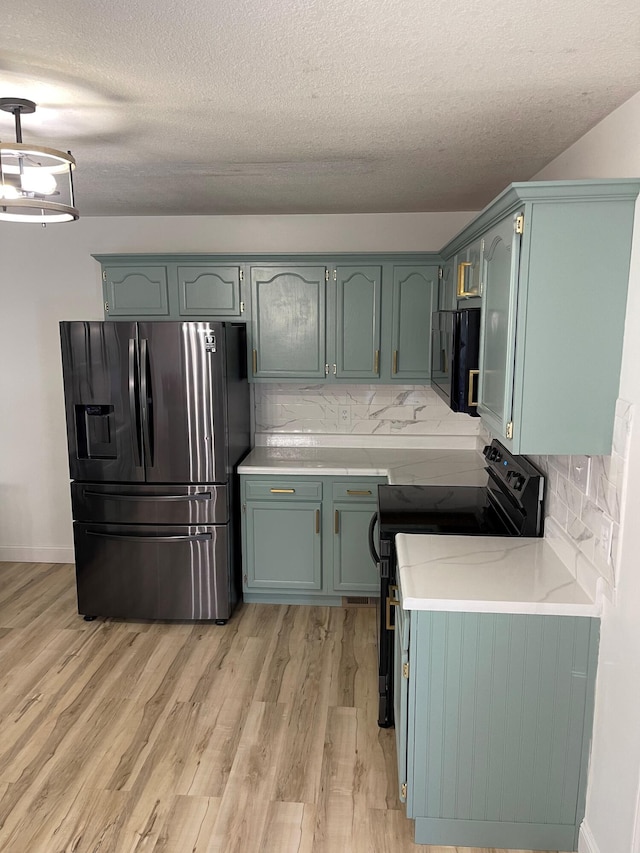 kitchen featuring a textured ceiling, black appliances, backsplash, and light hardwood / wood-style flooring