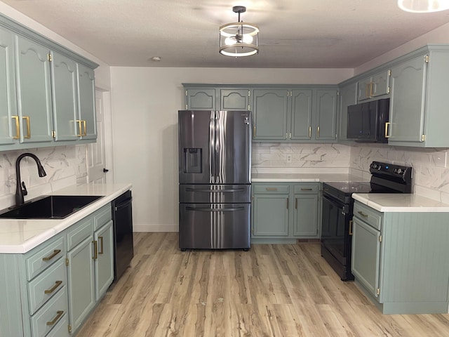 kitchen featuring light hardwood / wood-style flooring, sink, backsplash, black appliances, and a textured ceiling