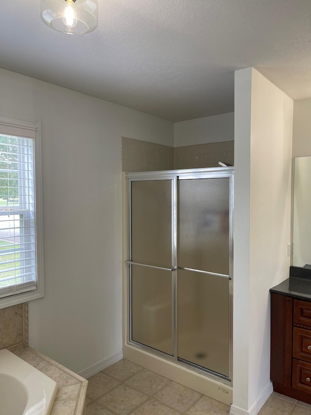 bathroom with vanity, separate shower and tub, tile patterned flooring, and a textured ceiling