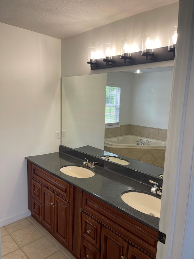 bathroom with a bathtub, tile patterned floors, vanity, and a textured ceiling