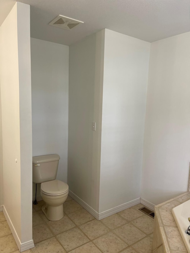 bathroom with toilet and tile patterned floors