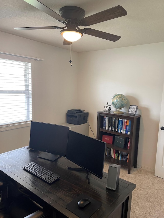 carpeted office space featuring ceiling fan