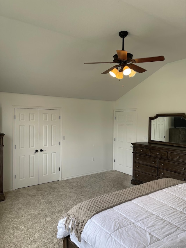 carpeted bedroom with ceiling fan, a closet, and vaulted ceiling