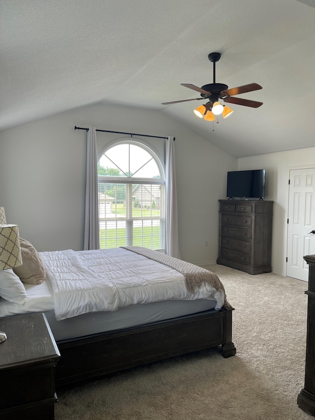 carpeted bedroom with ceiling fan, a textured ceiling, and vaulted ceiling