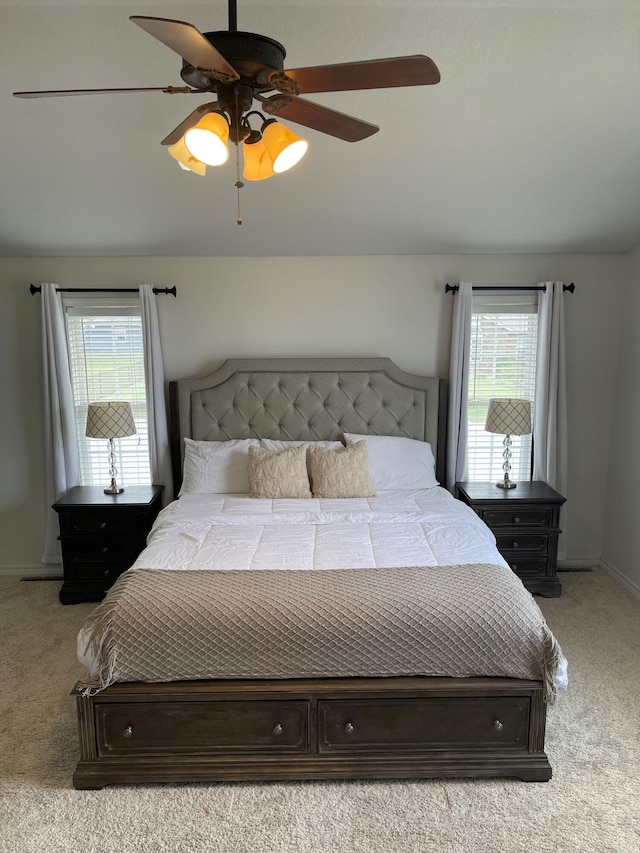 carpeted bedroom with multiple windows and ceiling fan