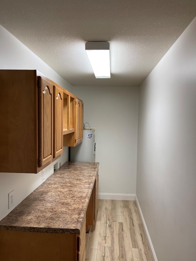 kitchen featuring a textured ceiling and light wood-type flooring