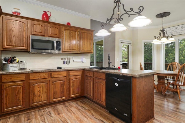 kitchen with light wood-type flooring, a notable chandelier, sink, hanging light fixtures, and black appliances