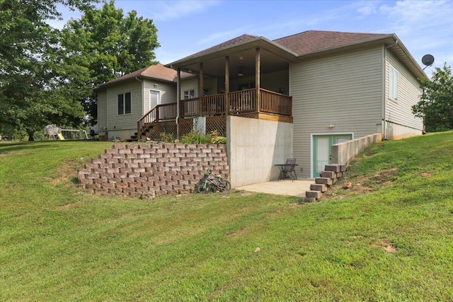 rear view of house featuring a yard and a deck