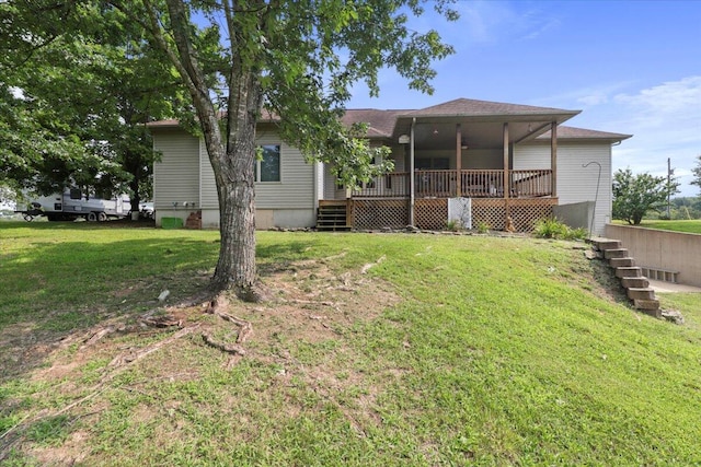 rear view of house featuring a deck and a yard