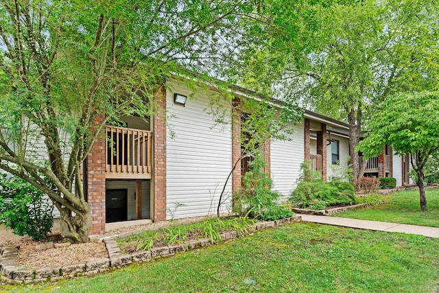 view of front of house featuring a balcony and a front lawn