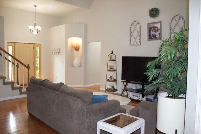 living room featuring high vaulted ceiling, an inviting chandelier, and wood-type flooring