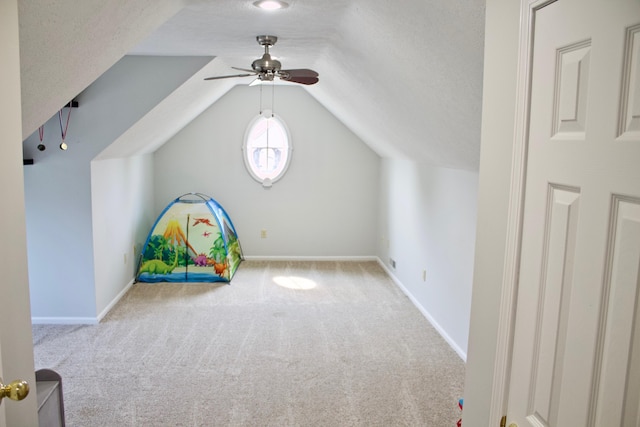 rec room featuring ceiling fan, light colored carpet, a textured ceiling, and lofted ceiling