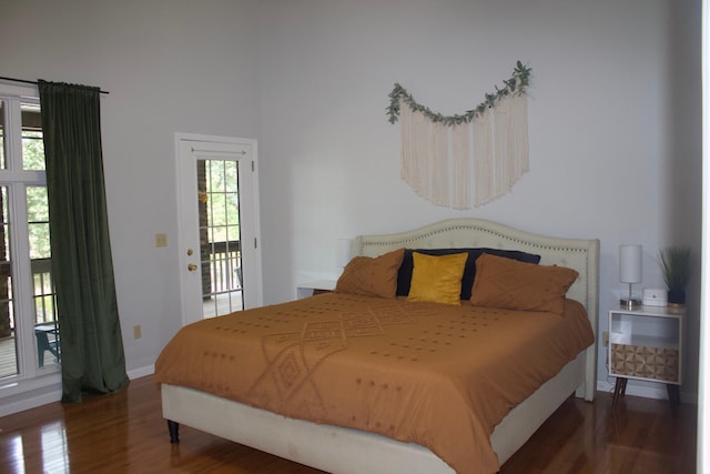 bedroom featuring access to outside, dark hardwood / wood-style floors, and multiple windows