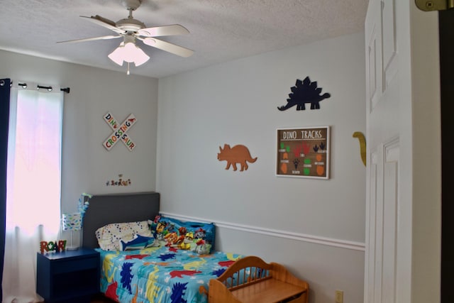 bedroom featuring a ceiling fan and a textured ceiling
