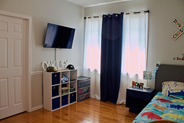 bedroom with multiple windows and wood finished floors