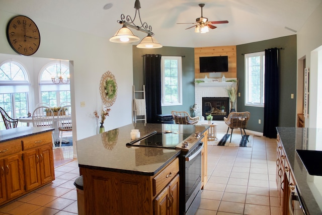 kitchen featuring pendant lighting, a center island, electric stove, and a wealth of natural light