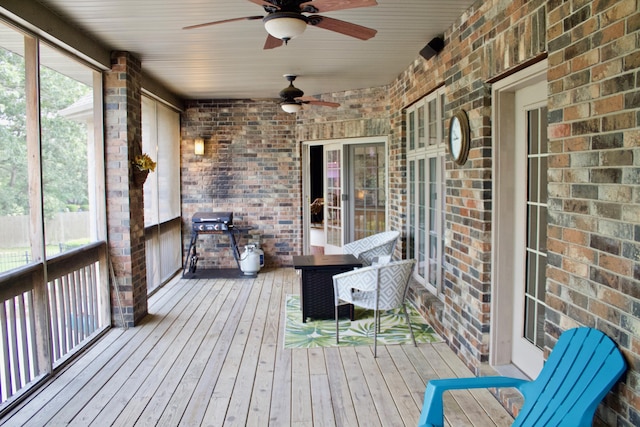 unfurnished sunroom featuring ceiling fan
