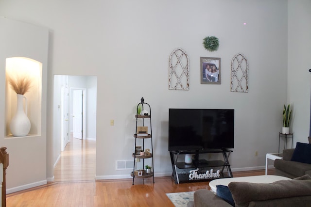 living room featuring wood finished floors, visible vents, and baseboards