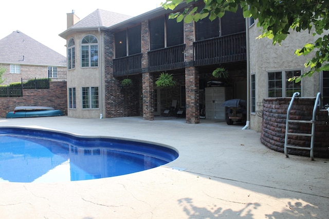 outdoor pool featuring grilling area and a patio area