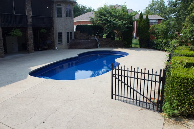outdoor pool featuring fence and a patio