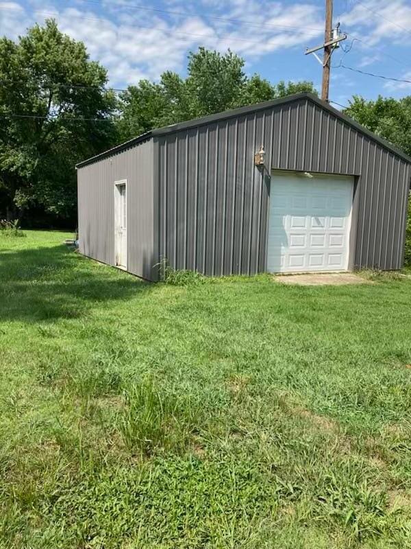 view of outdoor structure with a garage and a yard