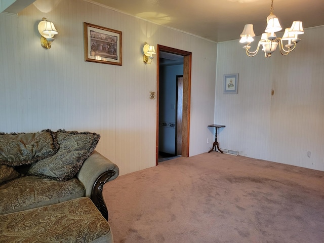 living room with crown molding, a chandelier, and carpet