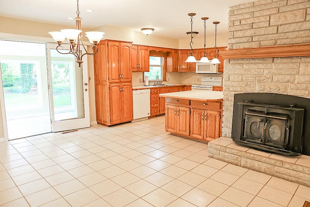 kitchen featuring a kitchen island, white appliances, sink, a notable chandelier, and hanging light fixtures