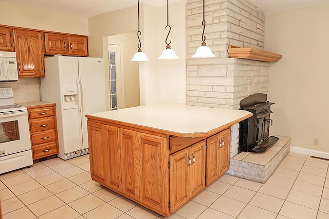 kitchen featuring light countertops, a wood stove, visible vents, light tile patterned floors, and white appliances