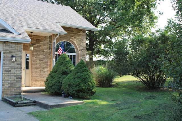 view of exterior entry with a lawn