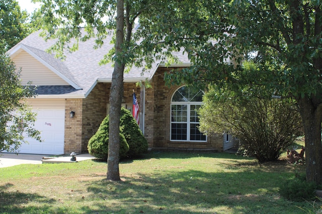 view of front of property with a front yard and a garage