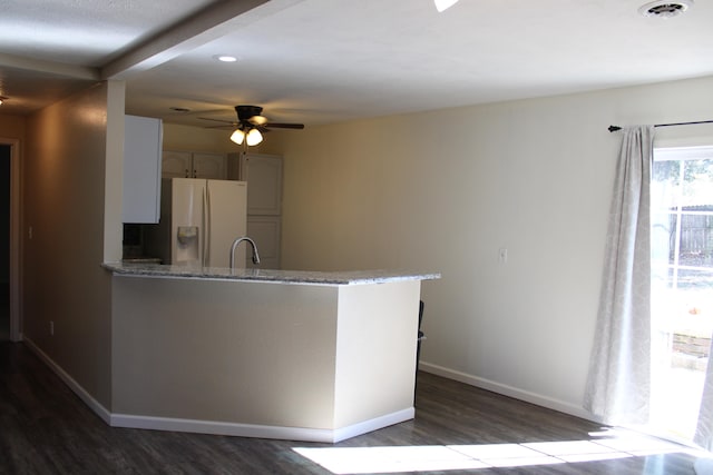 kitchen featuring ceiling fan, kitchen peninsula, dark hardwood / wood-style floors, and white fridge with ice dispenser