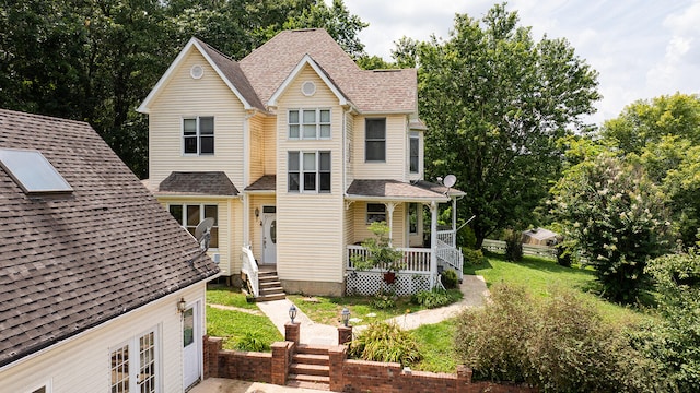 view of front of house with covered porch and a front lawn