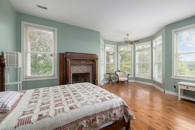 bedroom with a fireplace and light wood-type flooring