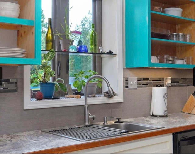 interior space with white cabinets, decorative backsplash, sink, and dishwasher