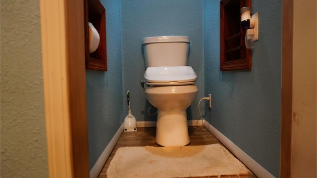 bathroom with hardwood / wood-style flooring and toilet