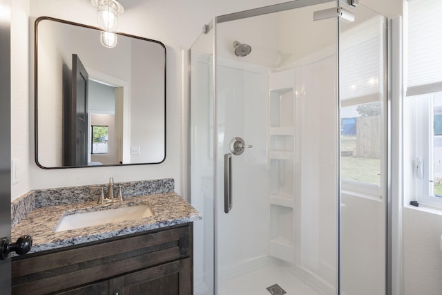 bathroom with a shower stall and vanity