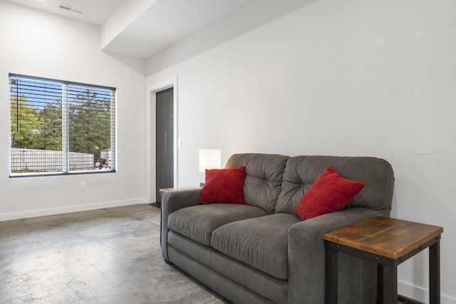 living room with baseboards, concrete floors, and visible vents